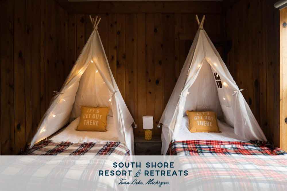 Experience-a-READtreat-at-South-Shore-4 Two cozy beds with white teepee canopies and plaid blankets create a welcoming atmosphere at South Shore Resort and Retreats, perfect for a relaxing getaway.| South Shore Resort & Retreats in West Michigan