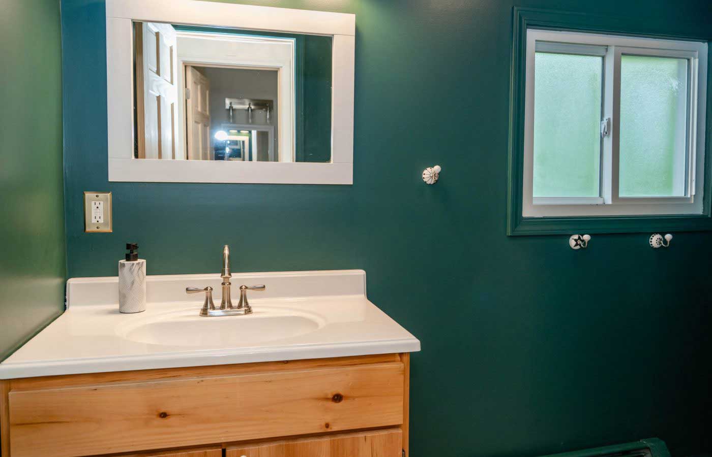 Bathroom vanity with green walls and mirror Bathroom vanity with green walls and mirror